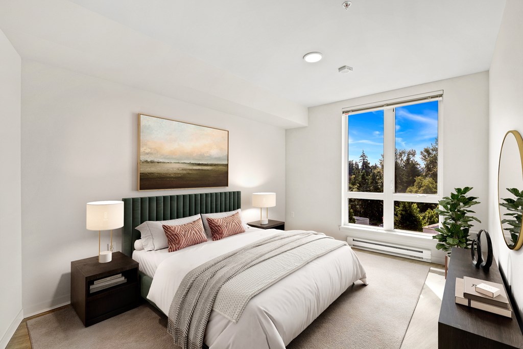 A bedroom with a large bed and a painting on the wall.
